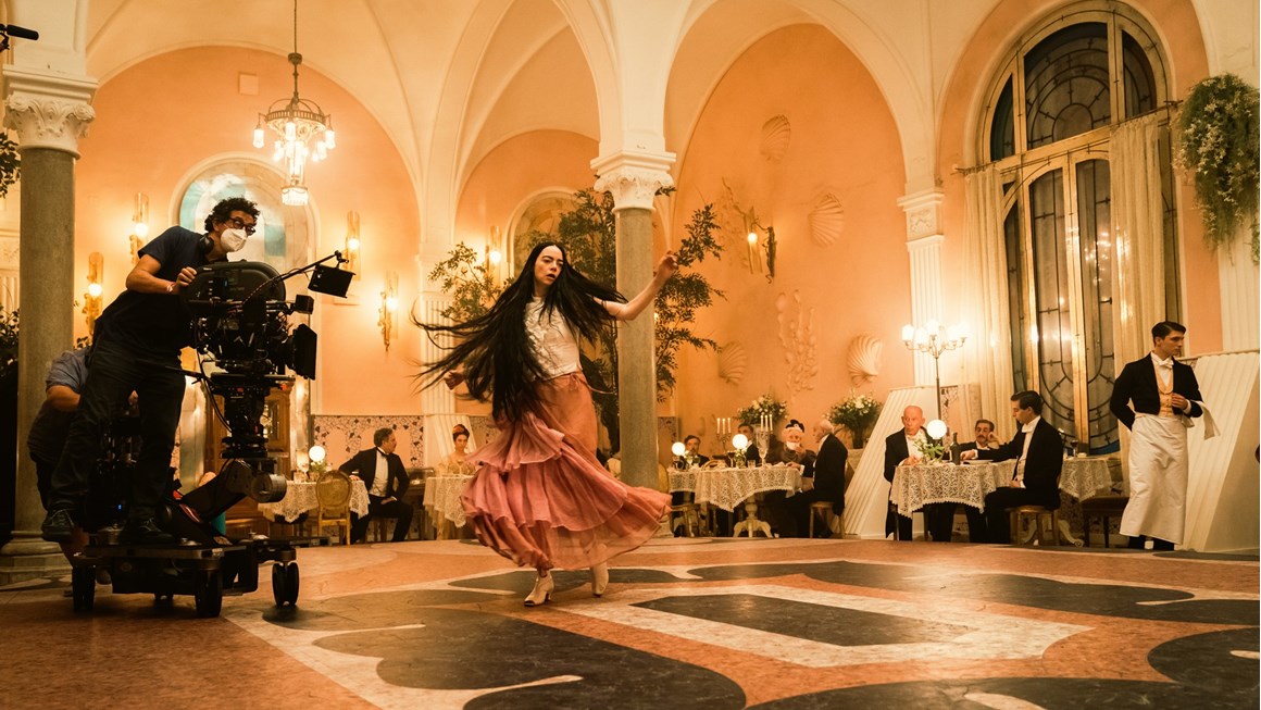 Emma Stone in a pink dress dancing in a ballroom