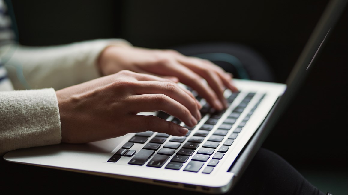 Close up of hands on a laptop keyboard